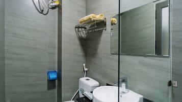 Et moderne badeværelse med toilet, håndvask og håndklædetørrestativ.