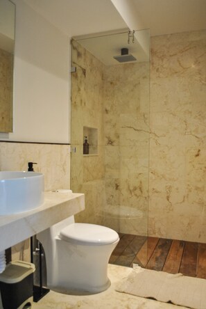 A bathroom with a marble sink, toilet, and a glass-enclosed shower area. - Celestial Penthouse with Private Jacuzzi (Tulum)