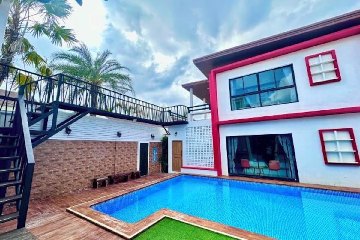 A two-story house with a swimming pool, a staircase, and a balcony.
