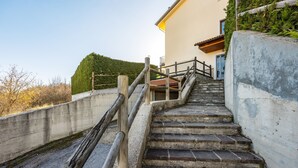 A set of stone steps leading up to a building with a wooden handrail and a concrete wall on one side. - Rifugio Marley in Pescocostanzo (Pescocostanzo)