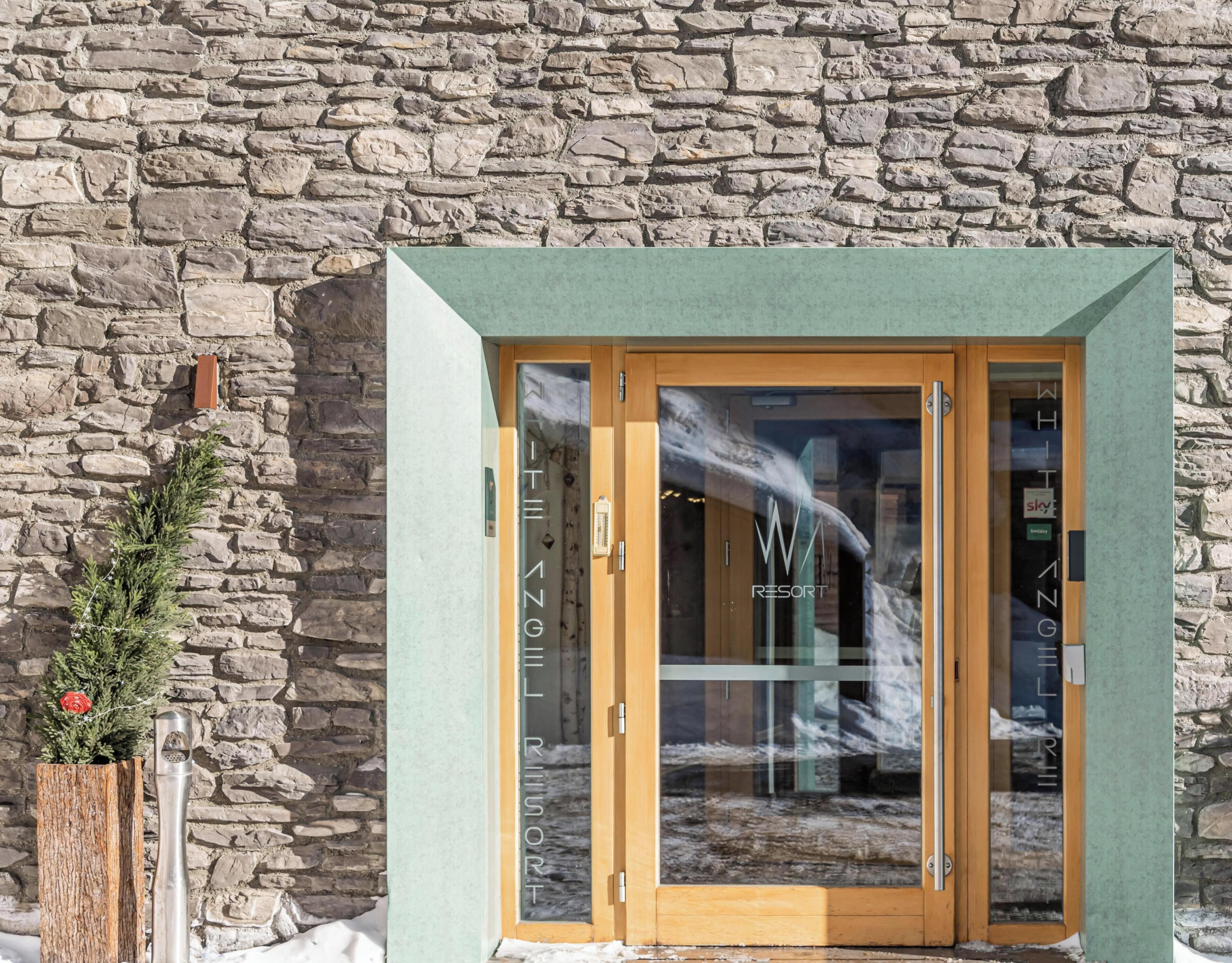 A stone building with a wooden door and glass panels.