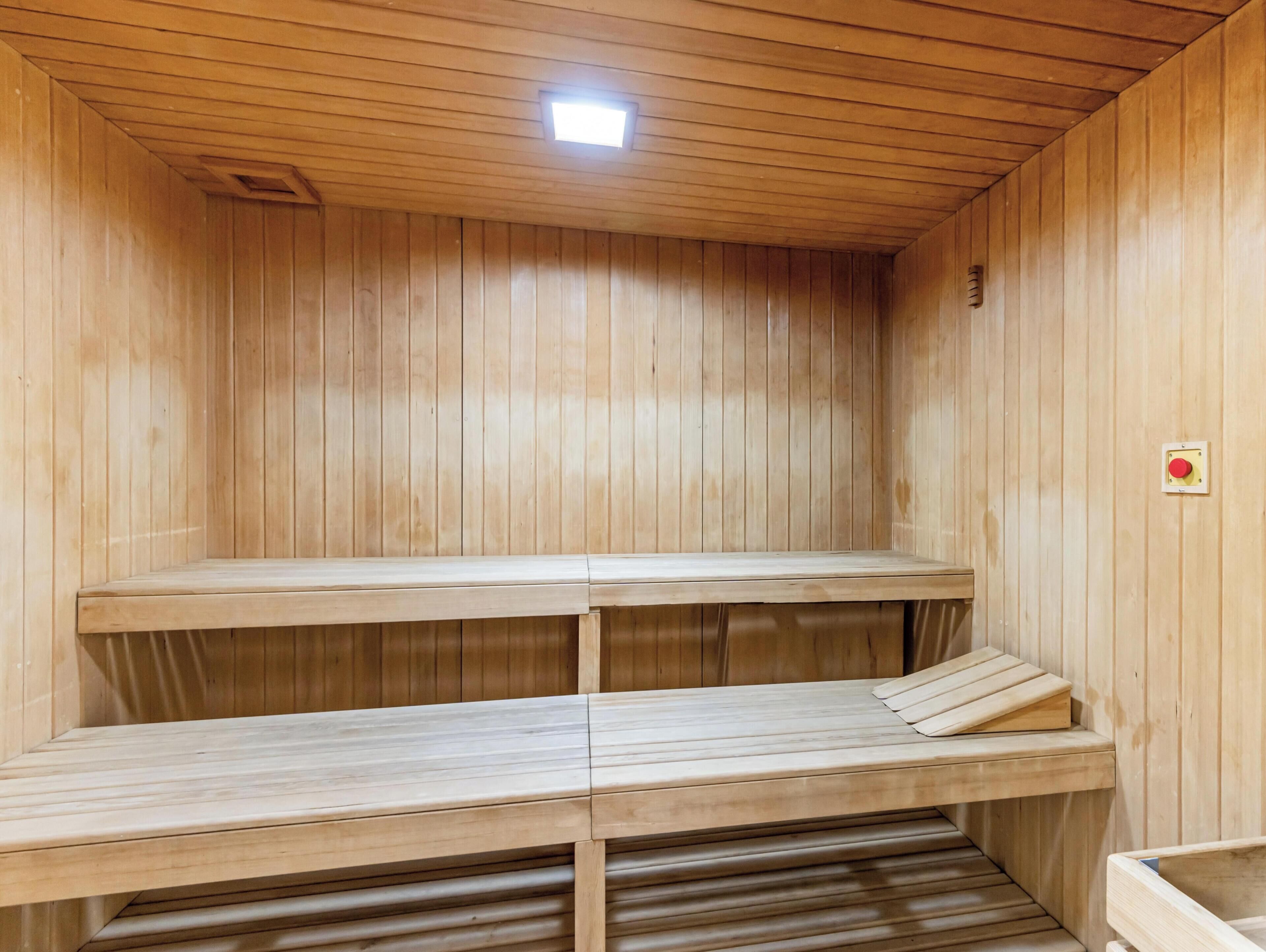 Eine Sauna mit Holzbänken und einer Deckenleuchte.
