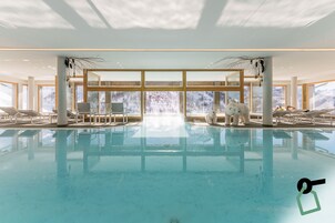 Una piscina techada, sillones reclinables de piscina