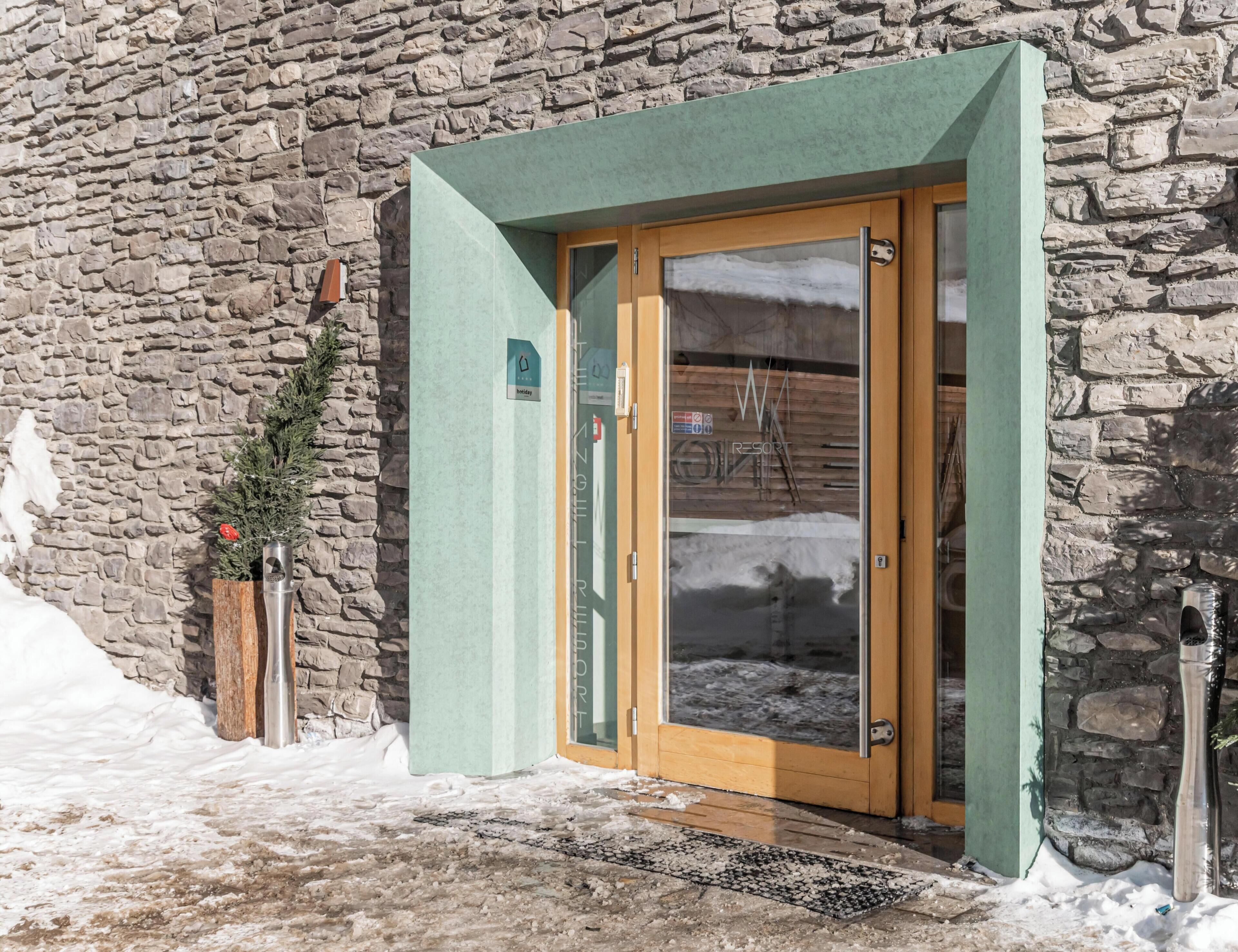 Un edificio de piedra con una puerta de madera y un toldo verde.