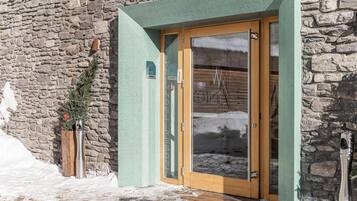 Un edificio de piedra con una puerta de madera y un toldo verde.