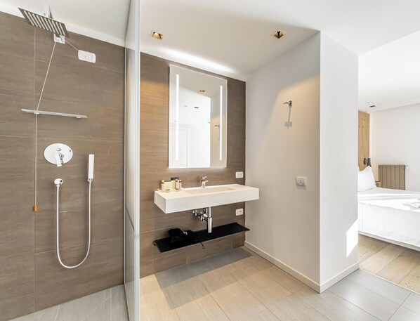 A modern bathroom with a shower, sink, and mirror.