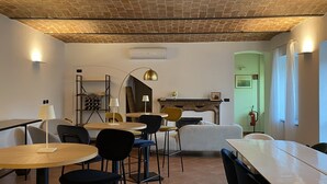 A cozy dining area with a brick ceiling, a fireplace, and a green door. - Cascina 1909 (Priocca)
