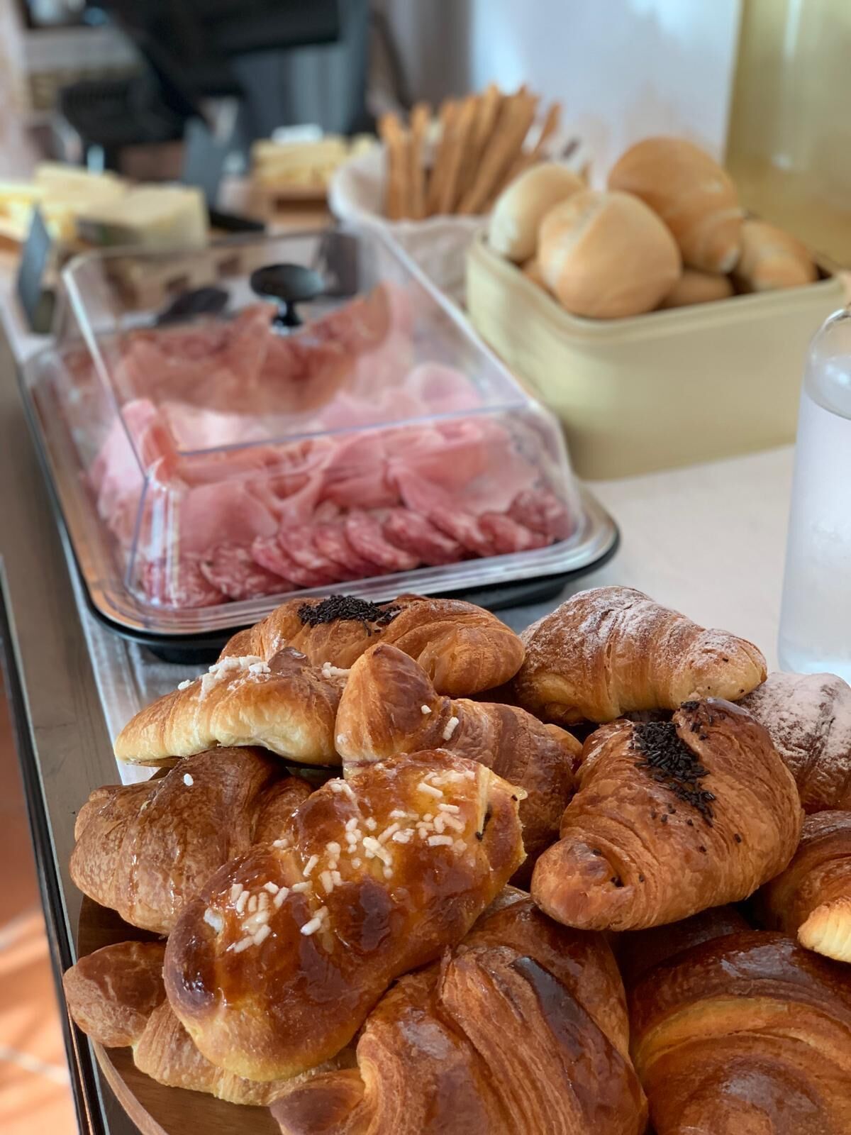 Un buffet proposant une variété de plats, notamment des pâtisseries et des viandes.