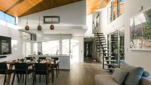 Una cocina amplia con comedor, una escalera y una sala de estar con sofá.