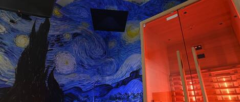 A room with a ceiling mural of a famous painting, a flat-screen TV, and a glass elevator.