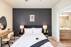 A modern hotel room with a large bed, bedside tables with lamps, a desk, and a chair. - Group-Friendly Apt with Pool,Gym,Parking,WD,Balcon (Tempe)