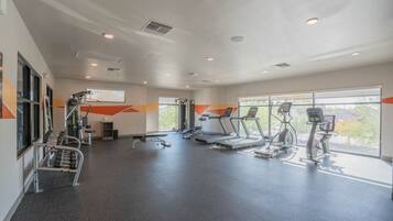 A gym with treadmills, elliptical machines, and weightlifting equipment.