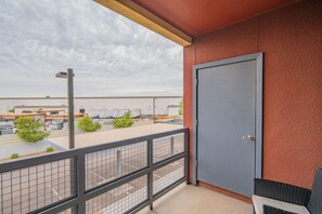A balcony with a view of a parking area and industrial buildings.