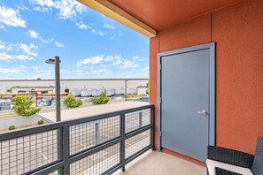 A balcony with a view of a parking lot and industrial buildings. - Family-Friendly Apt | Pool,Gym,W/D,Parking,Balcony (Tempe)