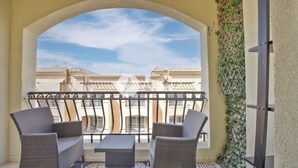 A balcony with wicker furniture and a view of buildings. - Cozy 1 BHK with City View in JVC by AZCO (Dubai)