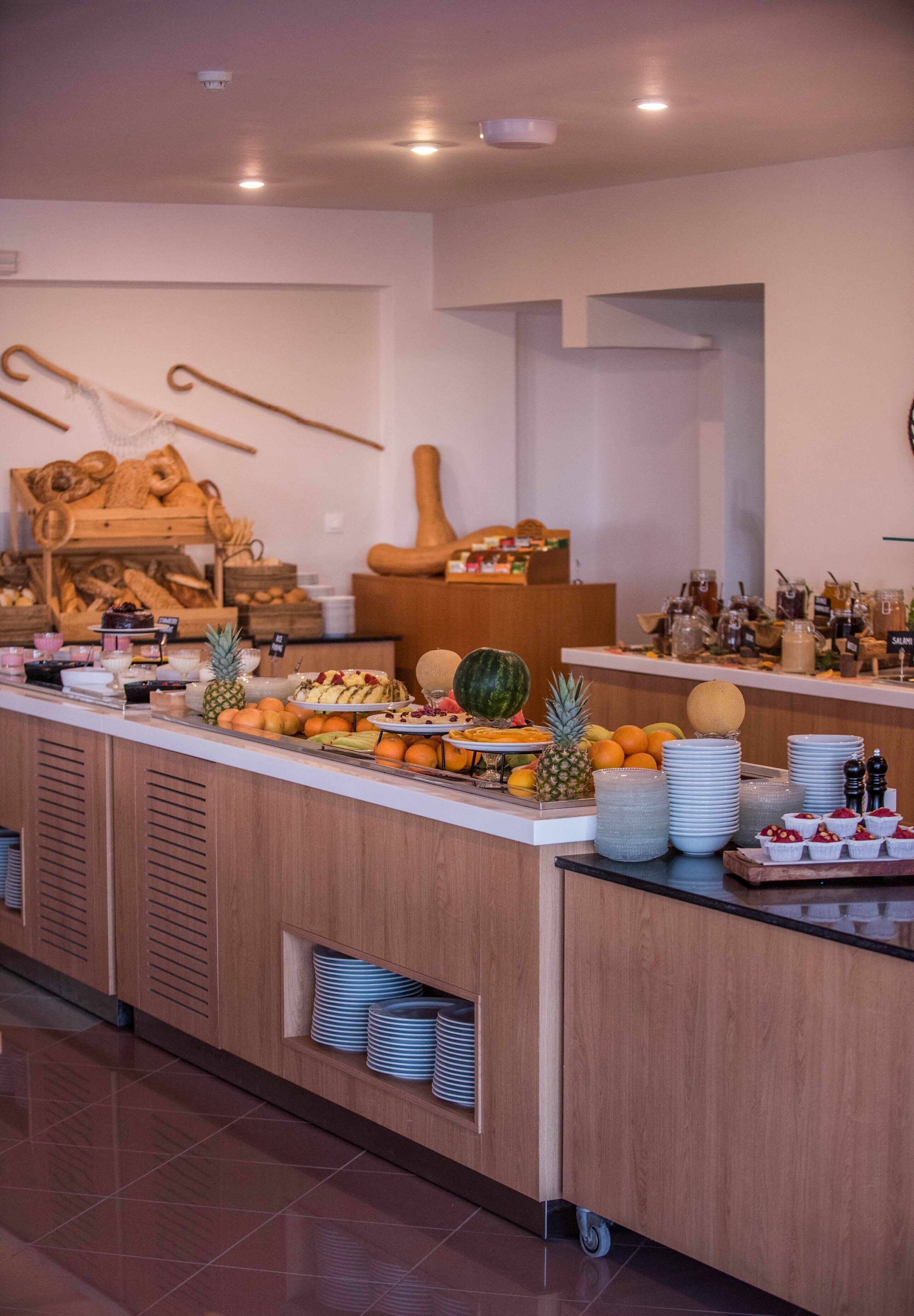 Un buffet proposant une variété de fruits, de boissons et de pâtisseries.