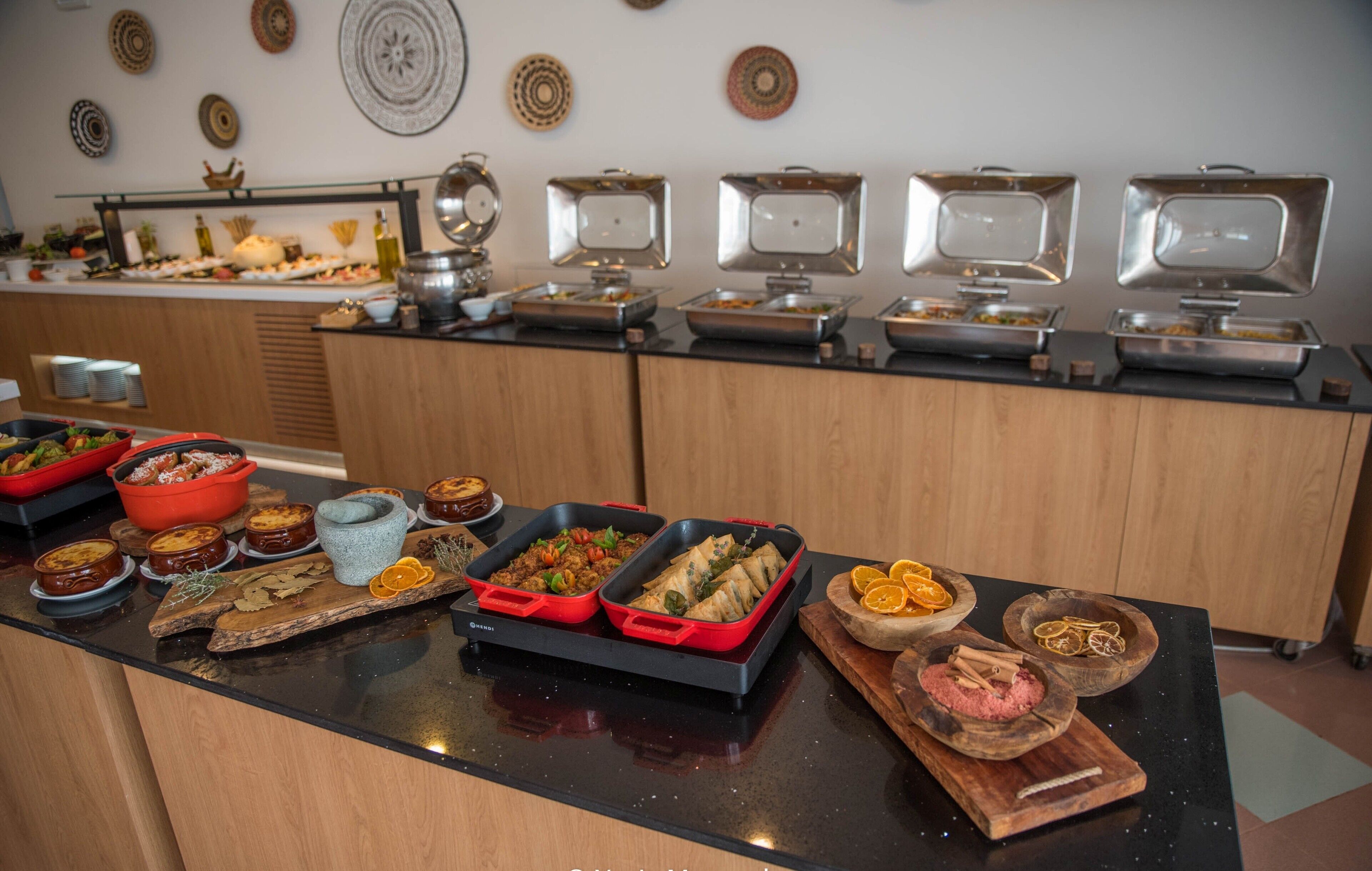 Una barra de buffet con diversos alimentos y utensilios para servir.