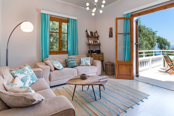A modern living room with a sofa, a coffee table, and a bookshelf.