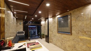 Un espace de bureau moderne avec un plafond en bois, un mur en marbre et une œuvre d’art encadrée.