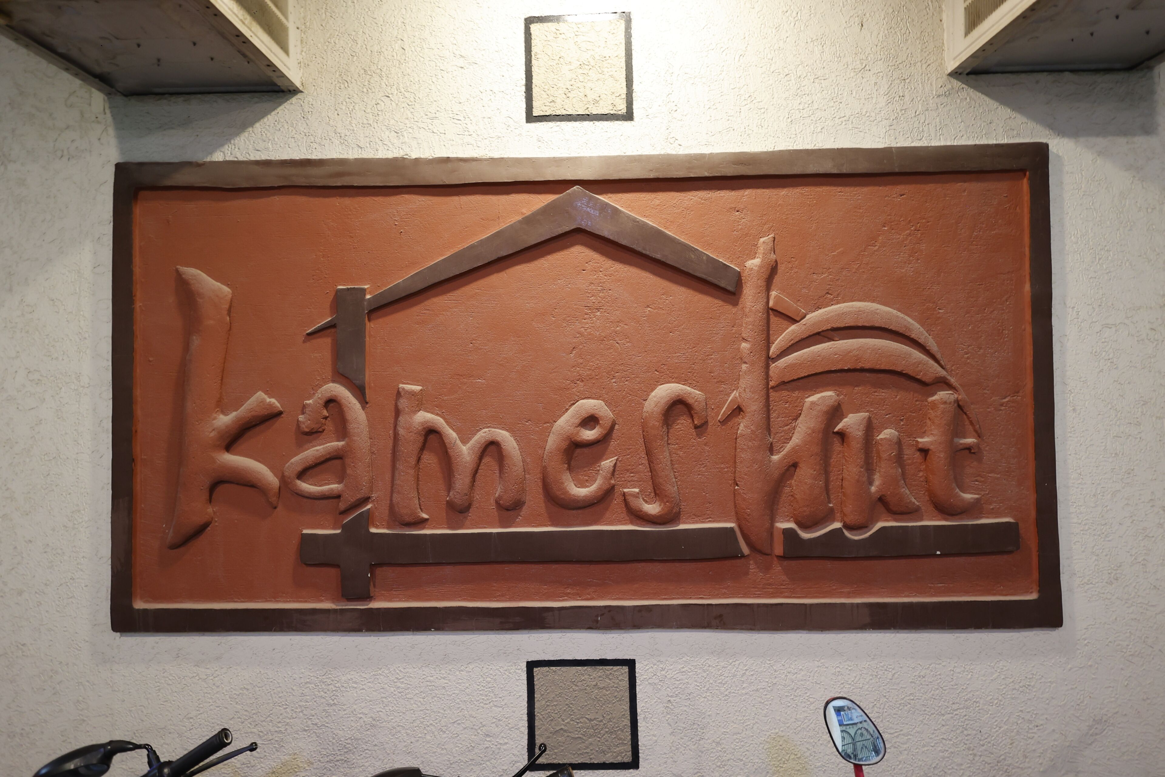 A wall-mounted sign with the name 'Kamertour' in a stylized font.
