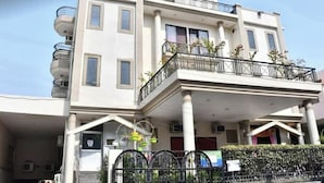 Un immeuble à plusieurs étages doté de balcons et d’un espace d’entrée abrité.