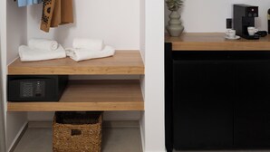Una habitación moderna con un estante de madera, un televisor de pantalla plana, una cafetera y una cesta.