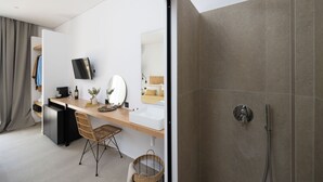 Un baño moderno con ducha, lavabo y espejo.