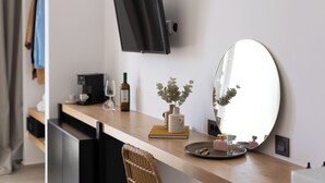 Cocina moderna con un televisor de pantalla plana montado en la pared, un espejo redondo y una encimera de madera con diversos objetos.