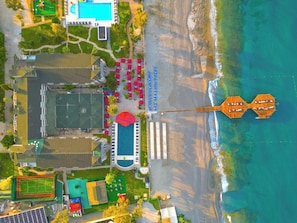 An aerial view of a coastal resort with a beach, a swimming pool, and a tennis court. - Senza Sunset Beach Hotel (Alanya)