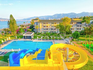 Ein Hotel mit Pool, Wasserrutschen und Meerblick.