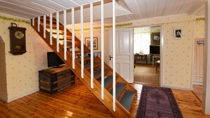 A wooden staircase with a cushioned landing, a vintage clock, and a rustic chest of drawers. - StayNordic | Idyllic holiday house in Sundshult | SE09011 (Hedekas)