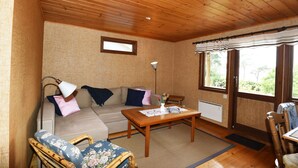 Una habitación acogedora con techo de madera, un sofá, una mesa de centro y una ventana con vistas.