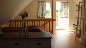 A room with a desk, a lamp, a window with curtains, a wooden staircase, and a ladder. - Functional and cozy studio at Abbekås Golf Course | SE01024 (Abbekås)