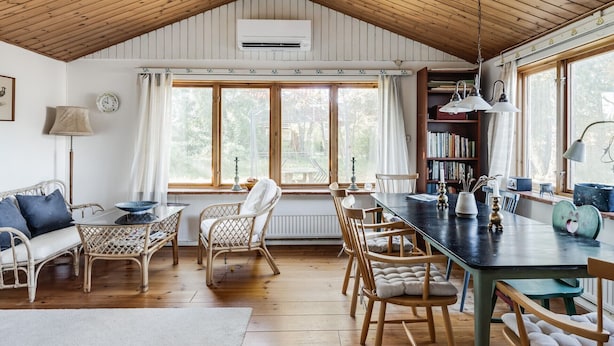 A cozy room with a wooden ceiling, a dining area with chairs, a table, and a bookshelf. - Nice holiday home near Skummelövs strand | SE02049 (Skummeslövsstrand)