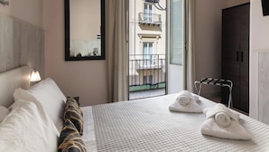 A hotel room with a bed, a mirror, a window with a view of a balcony, and a wardrobe. - Hotiday Room Collection - Palermo Politeama (Palermo)