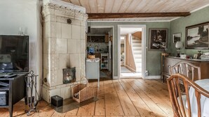 A rustic interior with a fireplace, wooden floors, and a dining area.