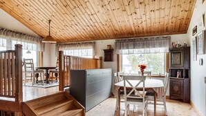 A wooden interior with a dining area, staircase, and kitchen.