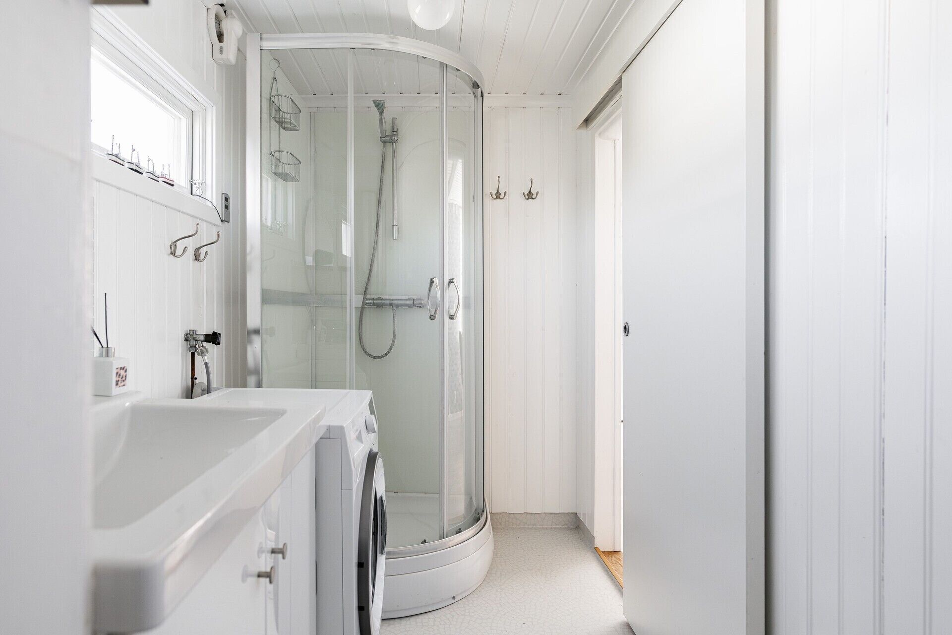 Une salle de bain moderne avec une douche à parois de verre, un lavabo blanc et des toilettes.