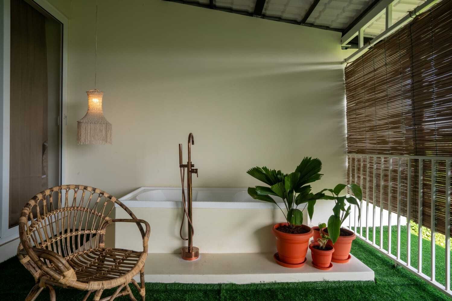 A spa area with a wooden chair, a massage table, a small tub, and potted plants.