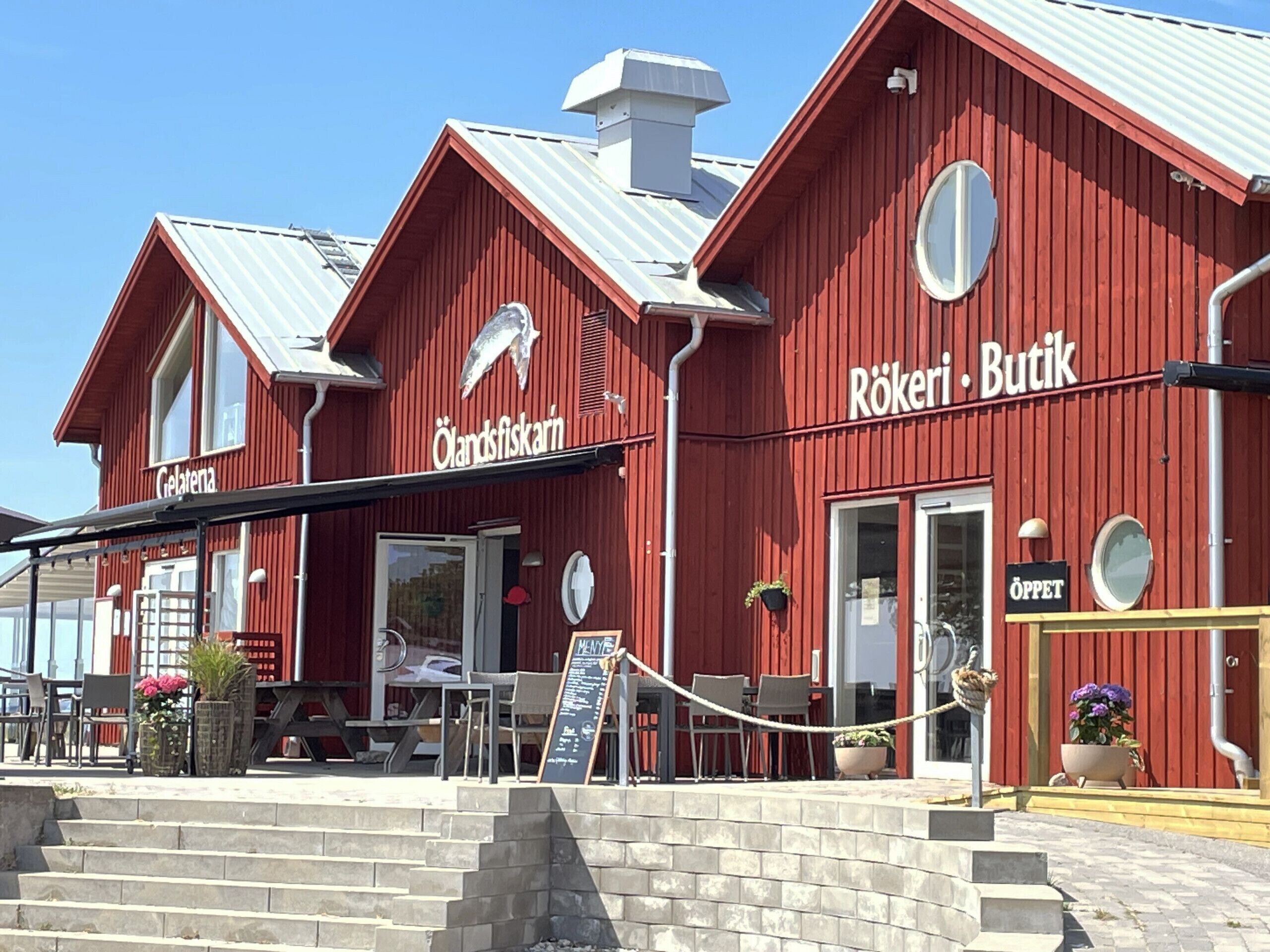 A red building with signs for 'Gelateran' and 'Rökeri Butik.'