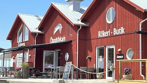 A red building with signs for 'Gelateran' and 'Rökeri Butik.' - Nice cottage located in the north of Öland next to Byxelkrok | SE04024 (Byxelkrok)