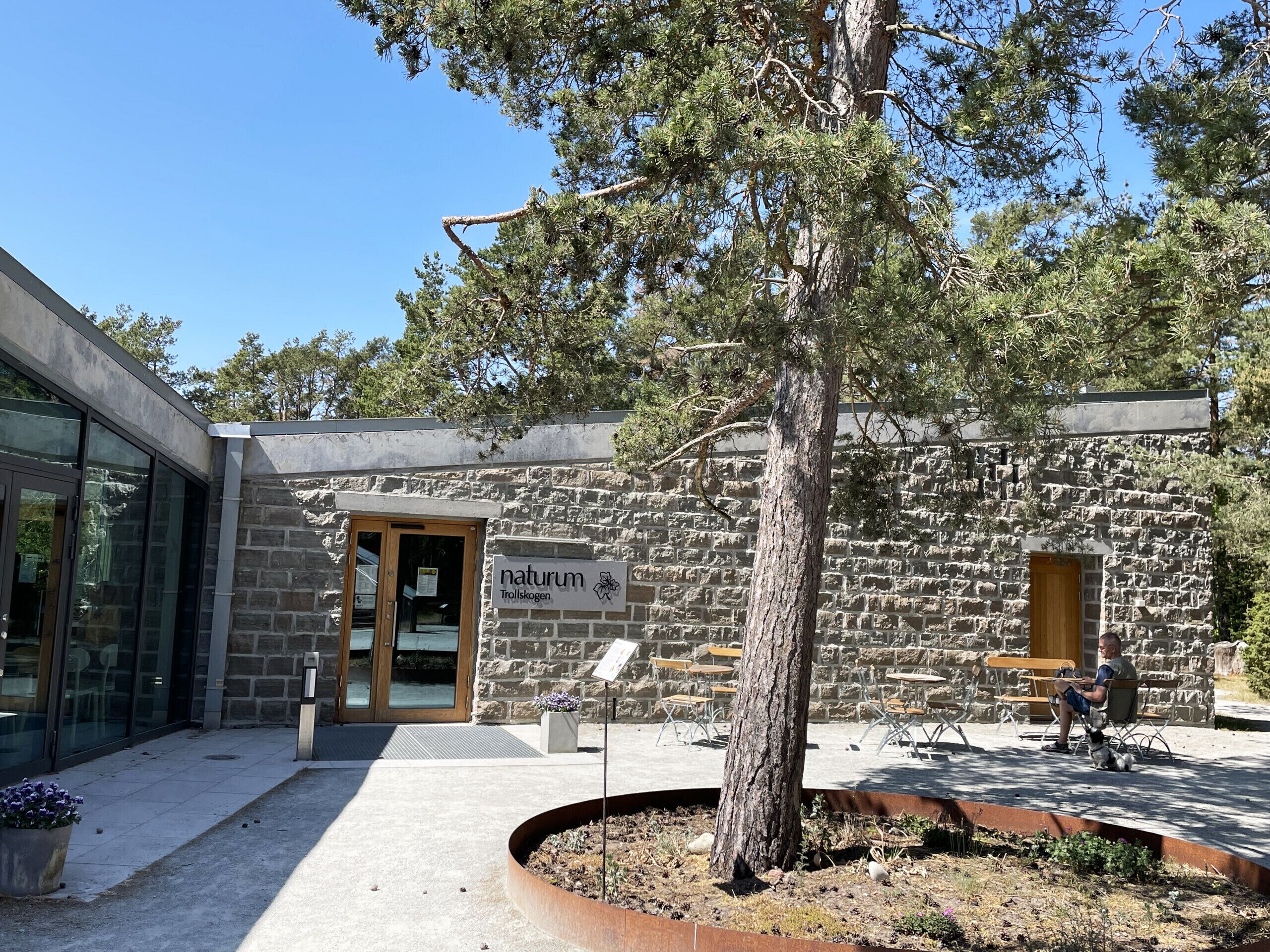 A stone building with a sign reading 'naturum Trollskogen.'