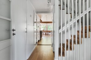 A hallway with white doors, a wooden floor, and a staircase with wooden steps. - Idyllic house in Mölnbo with heated pool near Gnesta | SE13025 (Mölnbo)