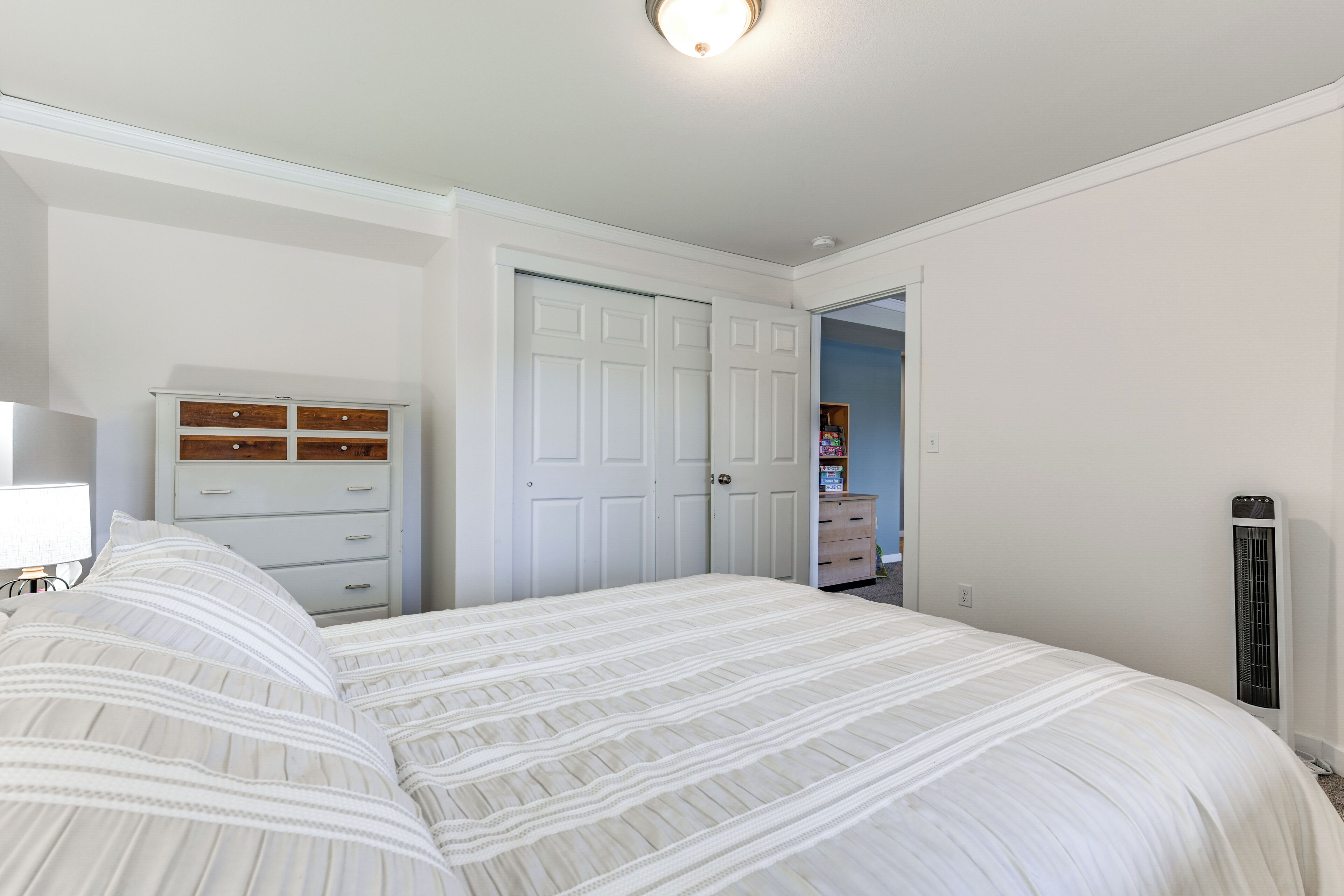 Une chambre à coucher comprenant un lit, une commode, une armoire et un radiateur.