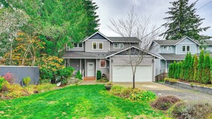A two-story house with a front yard, a garage, and a small porch. - Lakefront Gem w/ Deck & Grill in Shelton (Shelton)