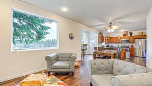 A spacious living room with a large window, a dining area, and a kitchen with modern appliances. - Lakefront Gem w/ Deck & Grill in Shelton (Shelton)