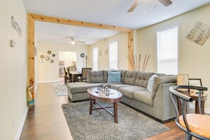 A living room with a sectional sofa, a round coffee table, and a dining area in the background. - 2 Mi to Syracuse University: Apt w/ Fire Pit (Syracuse)