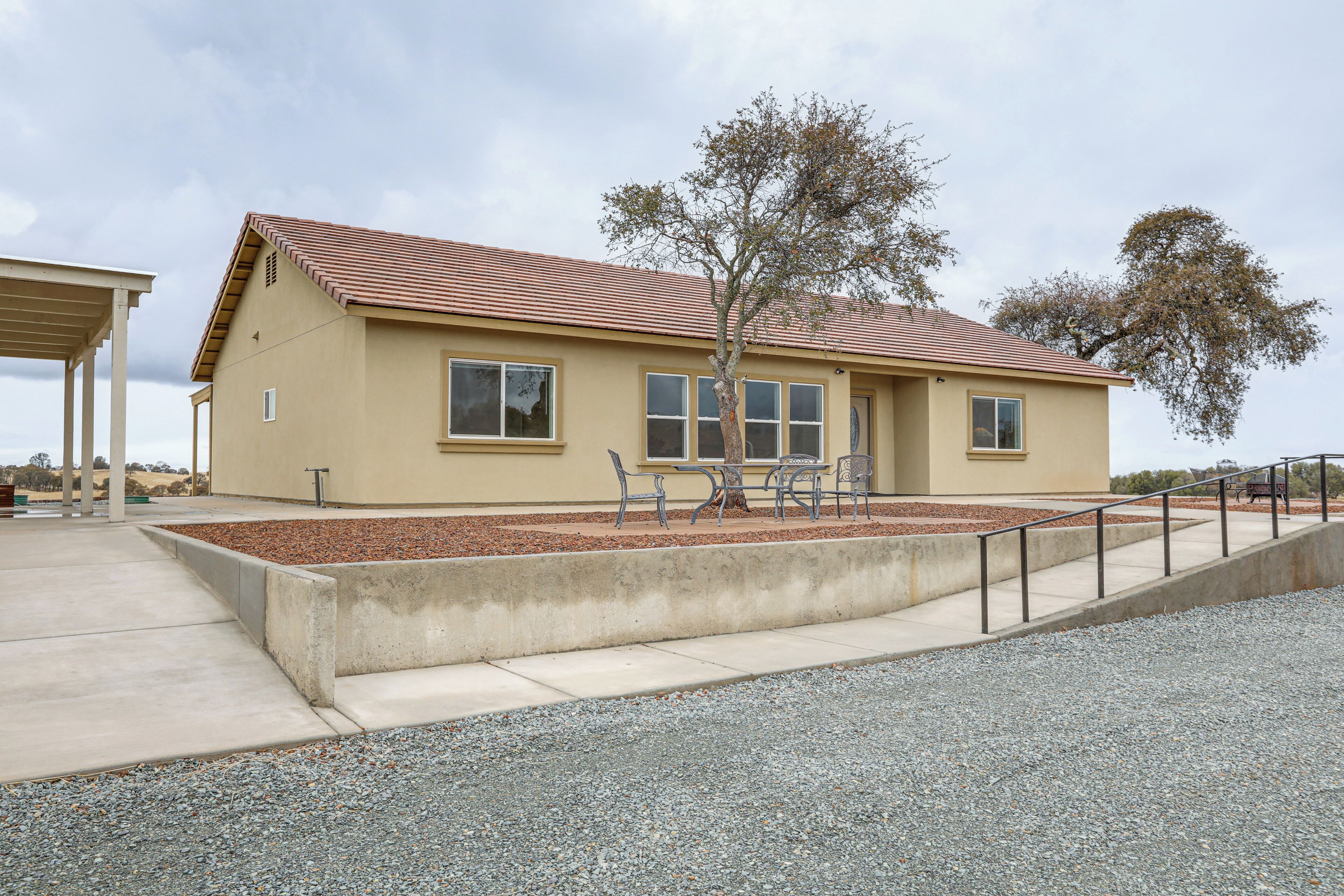 A single-story building with a flat roof, a small front porch, and a gravel driveway.