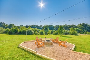 A fire pit area with four Adirondack chairs and a wooden deck. - 2 Mi to Dtwn Fulton: 'meadowlark' Home w/ Deck! (Fulton)