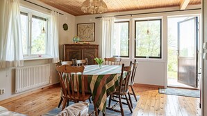 Un comedor con una mesa de madera, sillas y un globo terráqueo sobre un mueble.